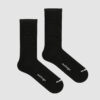 Pair of long black cycling socks by nologo shown in flatlay on a light grey background, highlighting minimalist design and extended cuff.